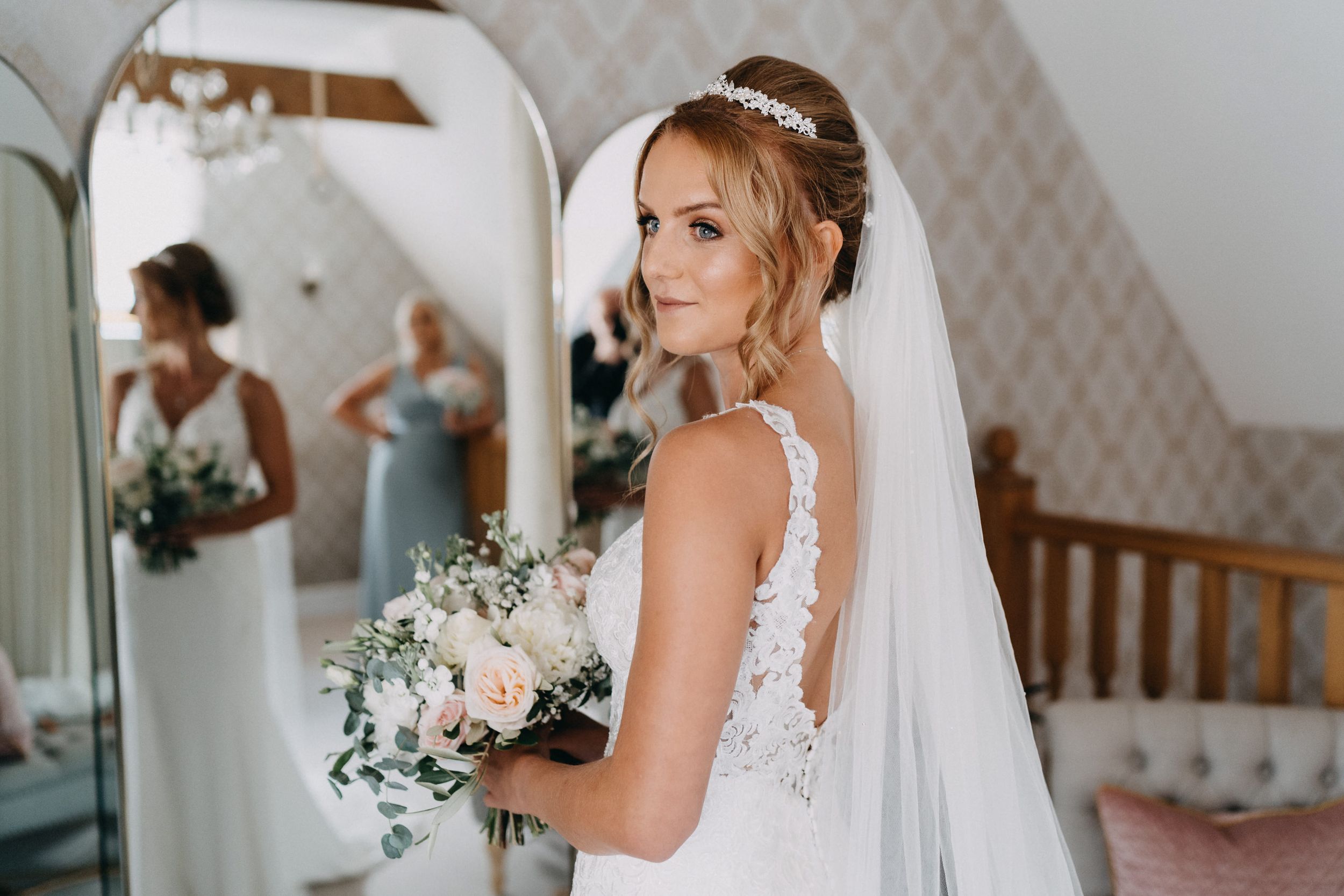 Wedding photography capturing bridal preparations with bouquet in elegant getting ready room.