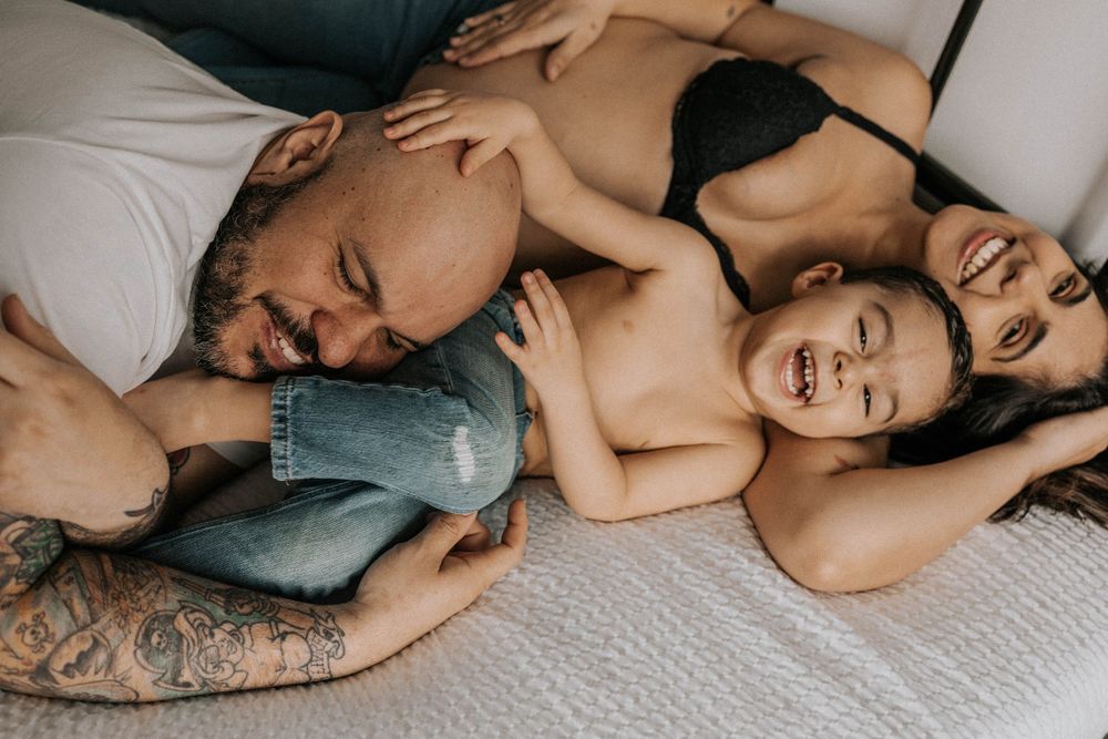 son, pregnant mother and dad hanging out at their bedroom at York region in Toronto