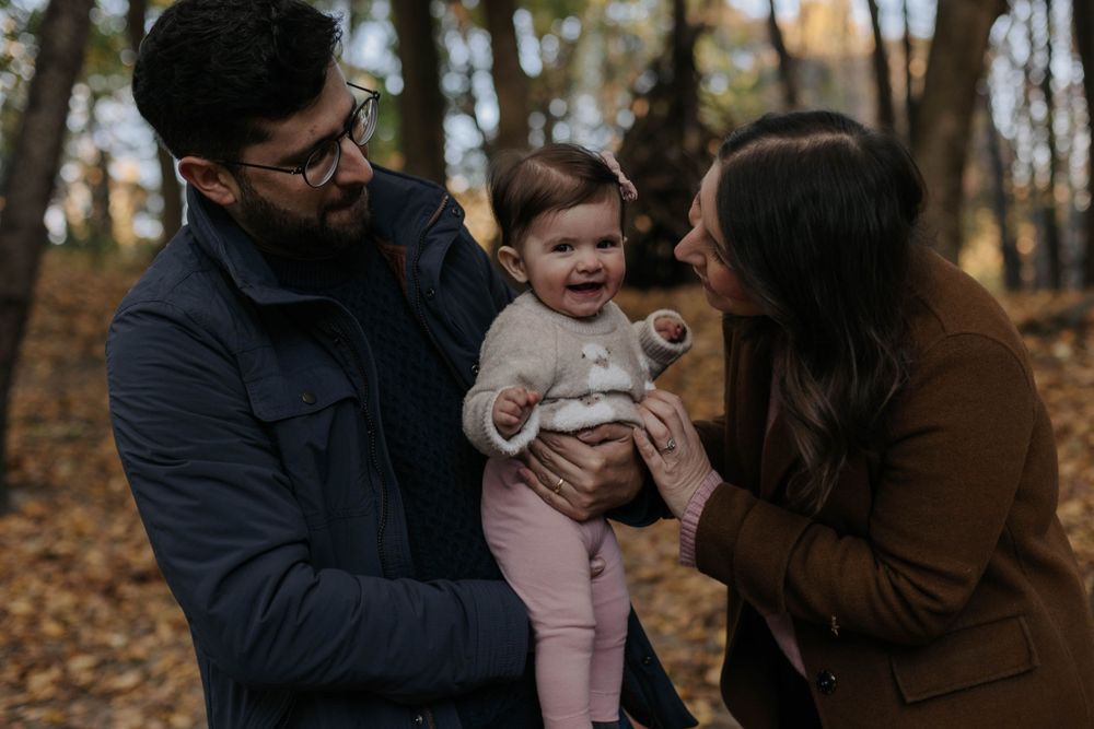 dad, mom and little baby hanging into the woods