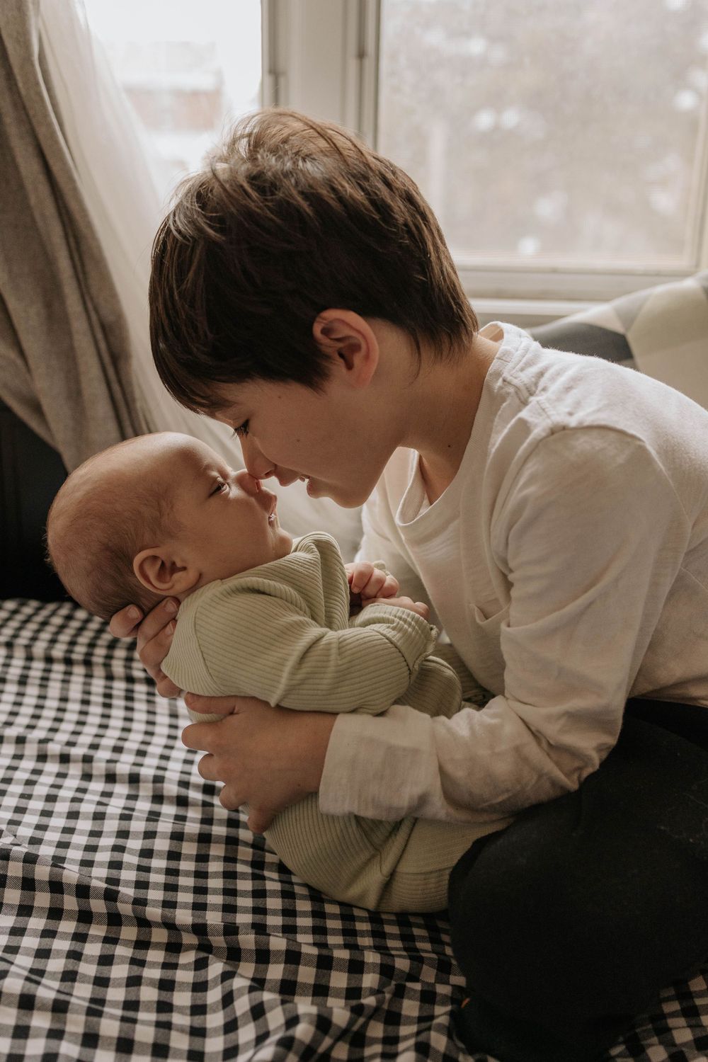 Big brother giving a skimo kiss in his newborn brother, in ther living room, in Etobicoke, Toronto