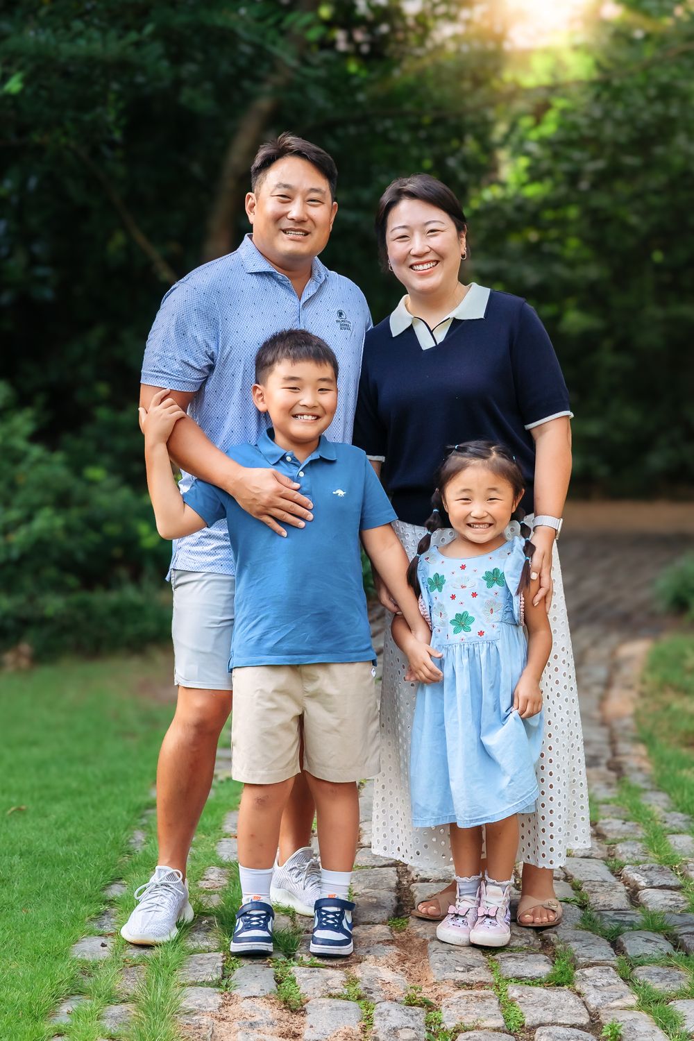 Sweet family moment captured at Founders Garden with blooming greenery and stone path in Athens GA by Ansley Howe Photography
