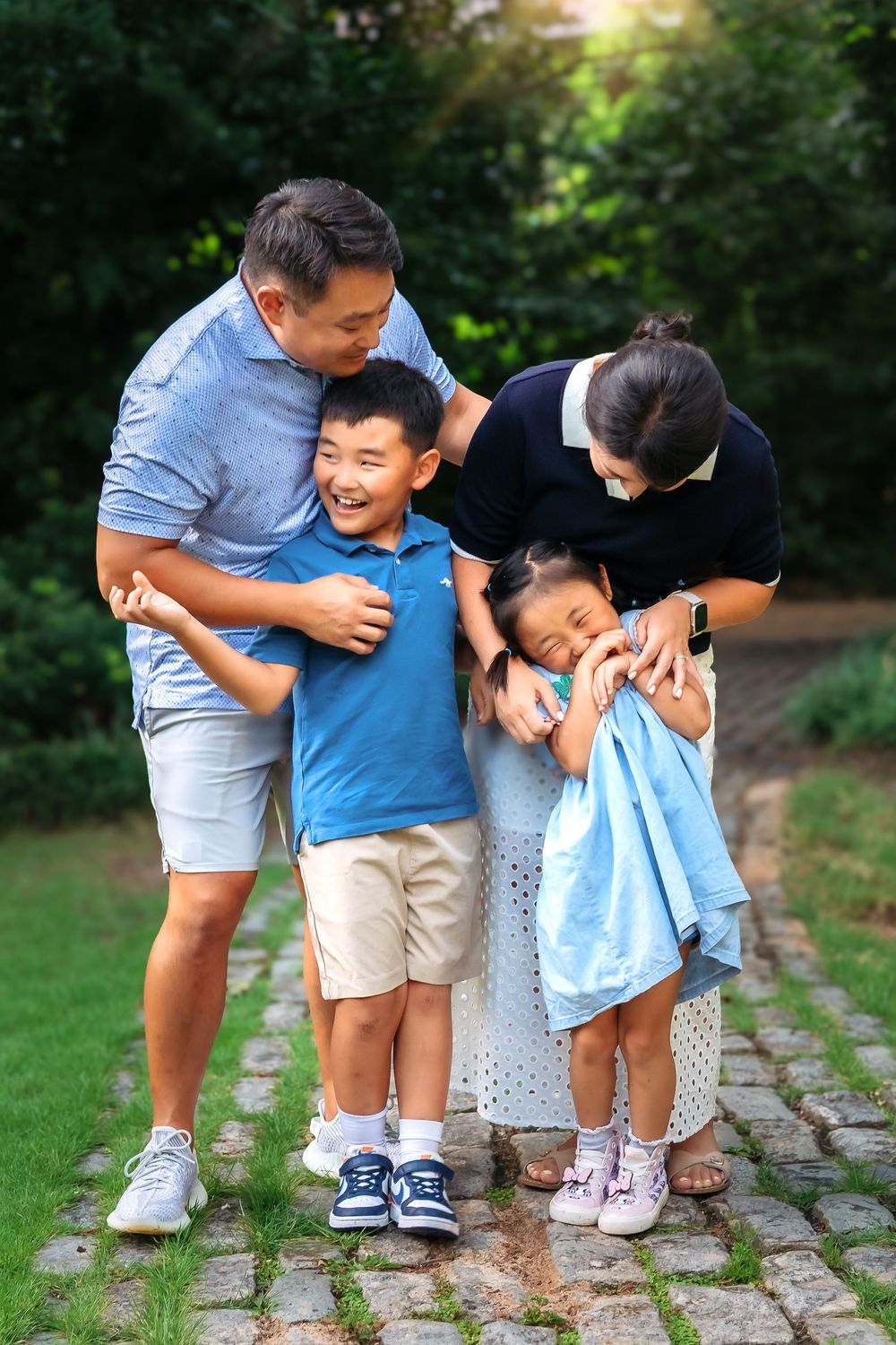 Sweet family moment captured at Founders Garden with blooming greenery and stone path