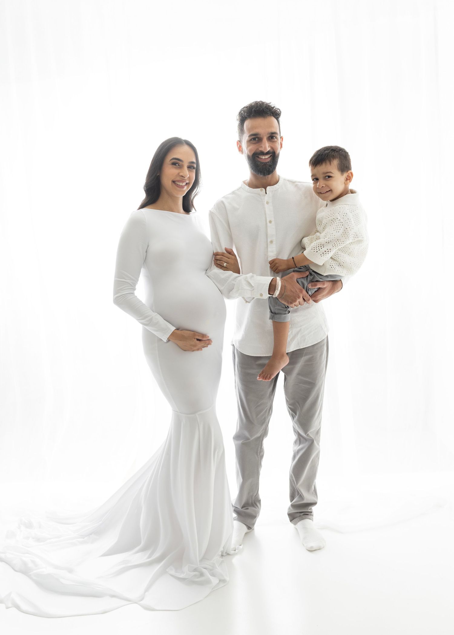 Elizabeth Lang Photography Surrey. mom dad and son maternity pose white backlit