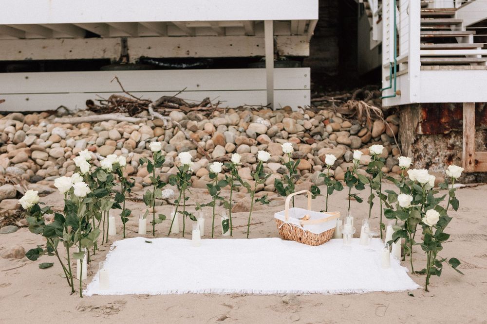 Long-stemmed red roses arranged in sand for a Montecito beach proposal.