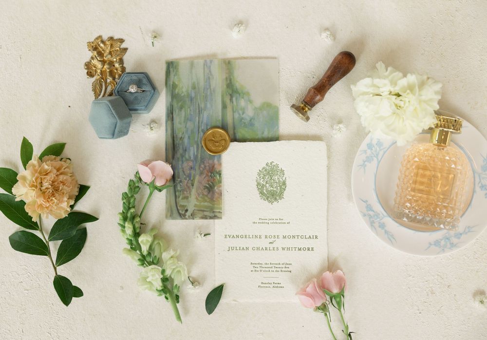 Vintage inspired flatlay with perfume bottles, flowers, and delicate pastel decor items arranged on cream background.