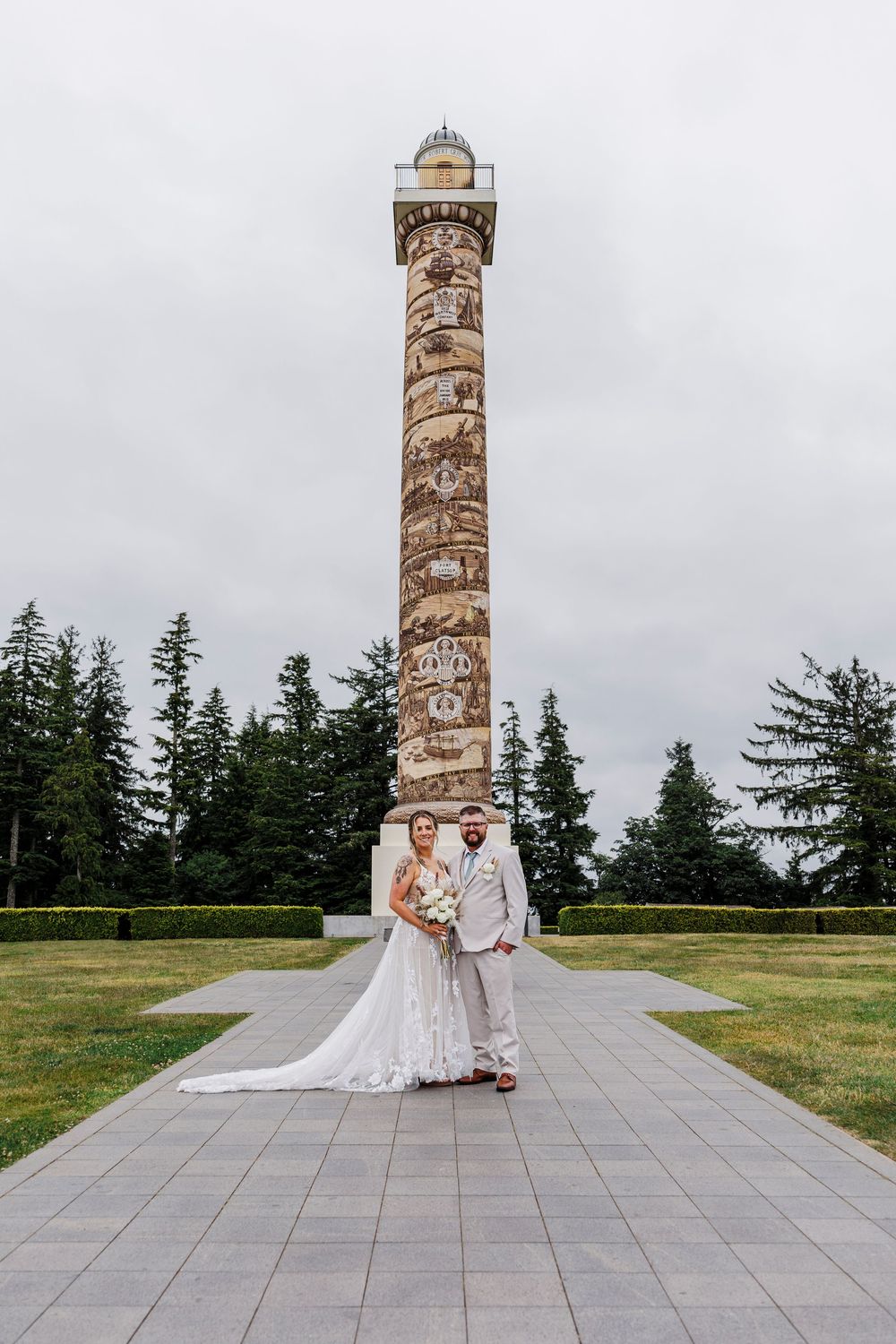 Wedding portrait in front of the Astoria Column with evergreen trees in the background.