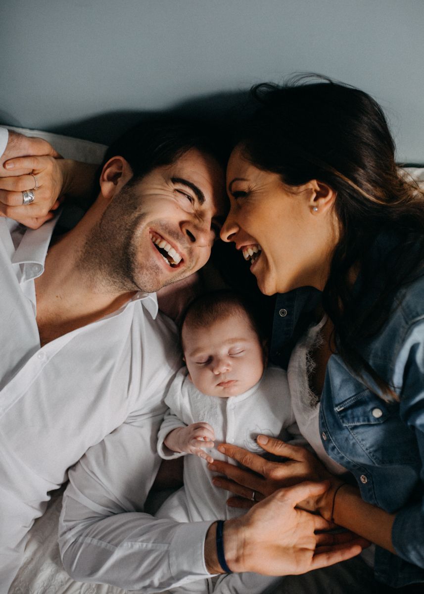 Family of three sharing joyful moment together on bed.