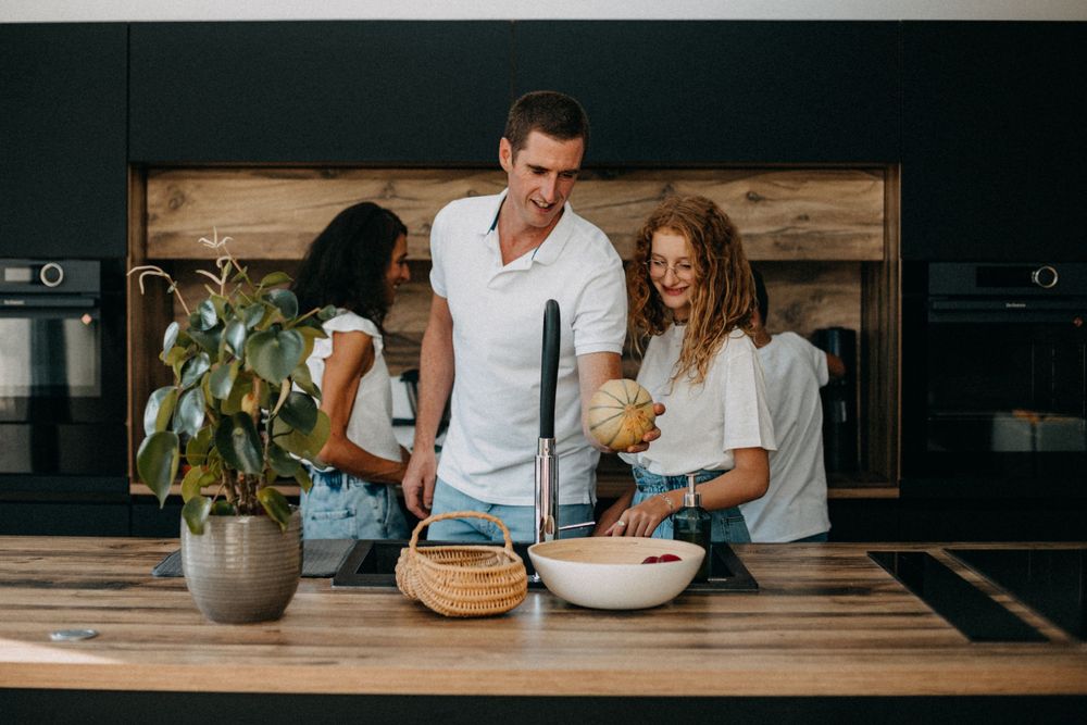 Couple preparing food together in a modern kitchen with wooden details.