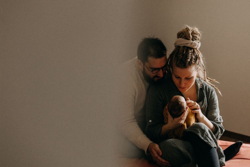 Warm toned lifestyle photo of family sharing tender moment with their baby.