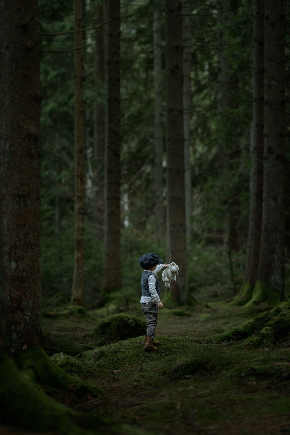 Pojke klädd i gammaldags kläder som upptäcker i skogen.