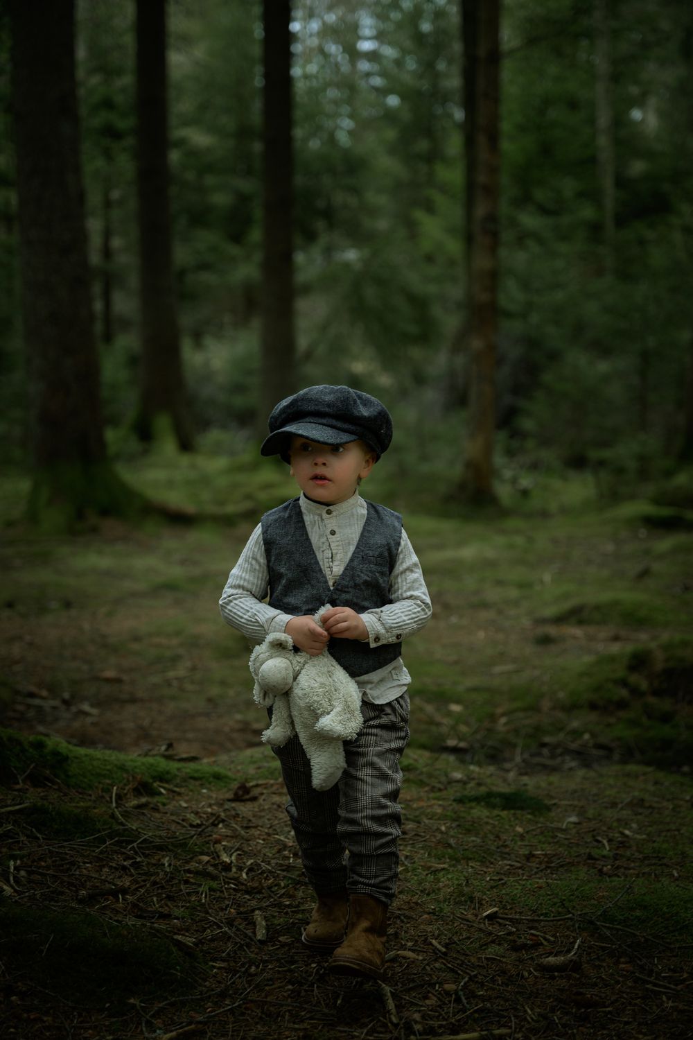 Pojke klädd i gammaldags kläder som upptäcker i skogen.
