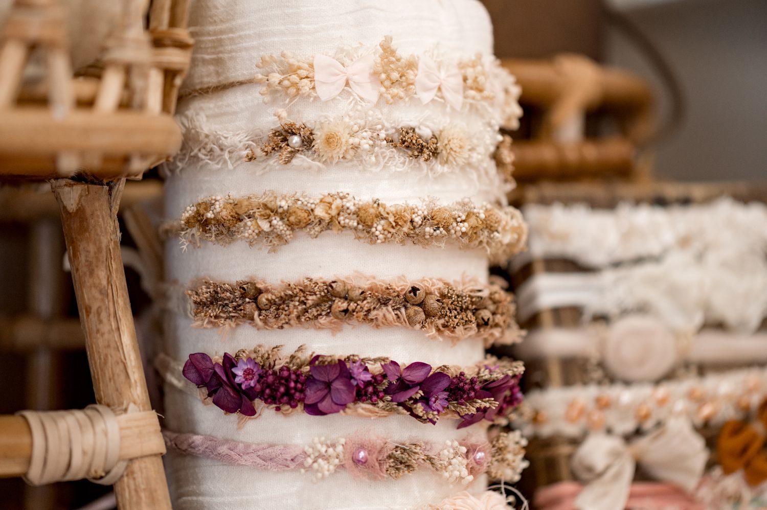 Stack of fluffy white bath loofahs with purple accents and natural exfoliating texture on wooden shelf.