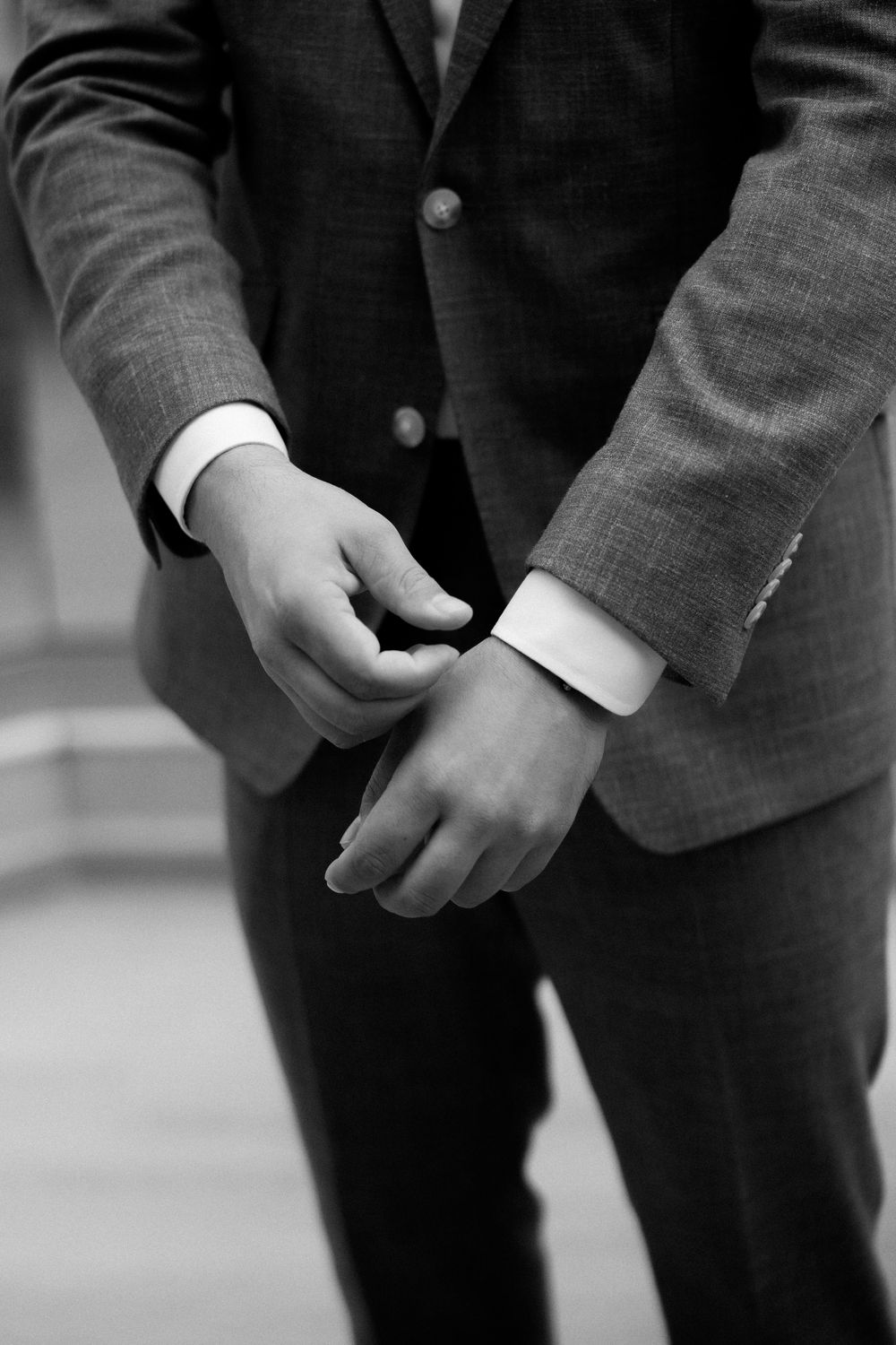 Close-up of hands adjusting suit cuff links in black and white. Wedding Agreco Farms, Crete