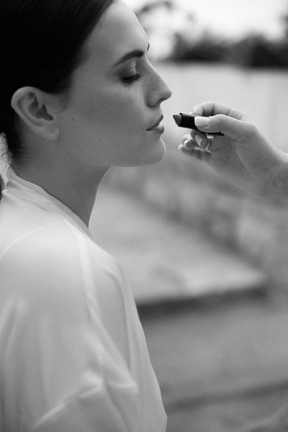 Profile view of someone having makeup applied during wedding preparation. Wedding Agreco Farms, Crete