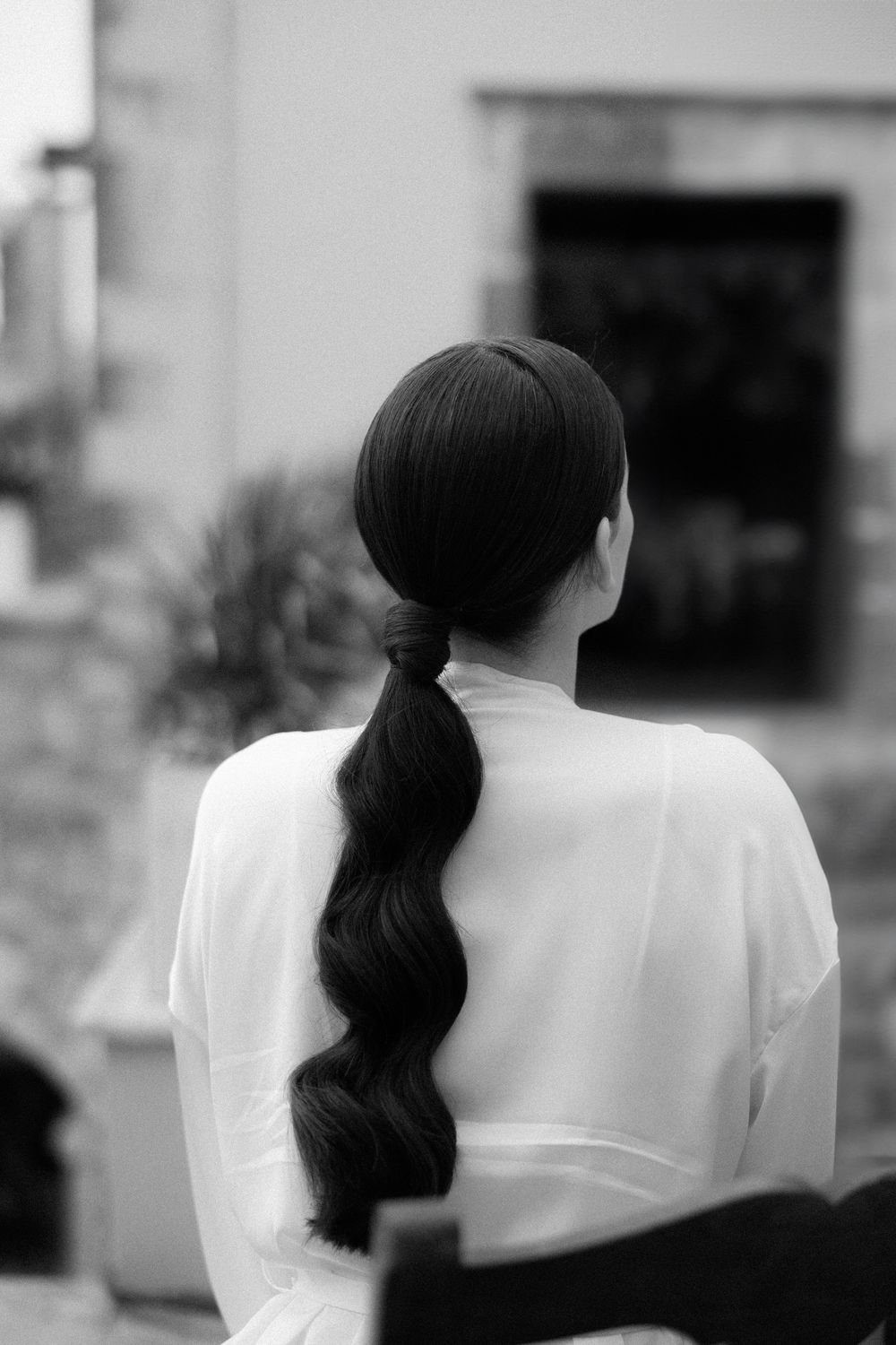 Back view of person with long wavy ponytail wearing white top. Wedding Agreco Farms, Crete