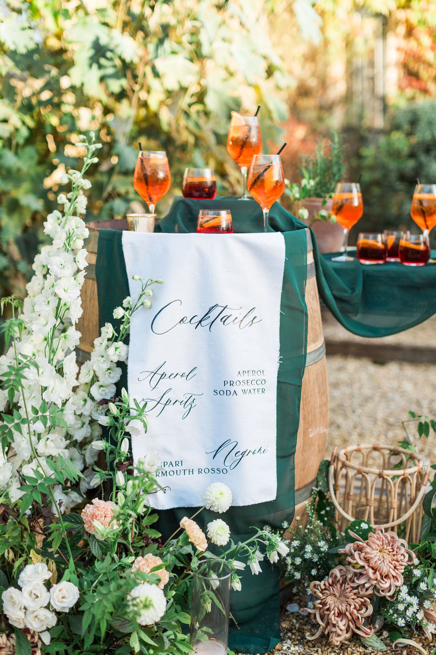 Elegant garden wedding dinner cocktail bar setup with abundant floral arrangements and calligraphy signage Merriscourt Hayley Elizabeth