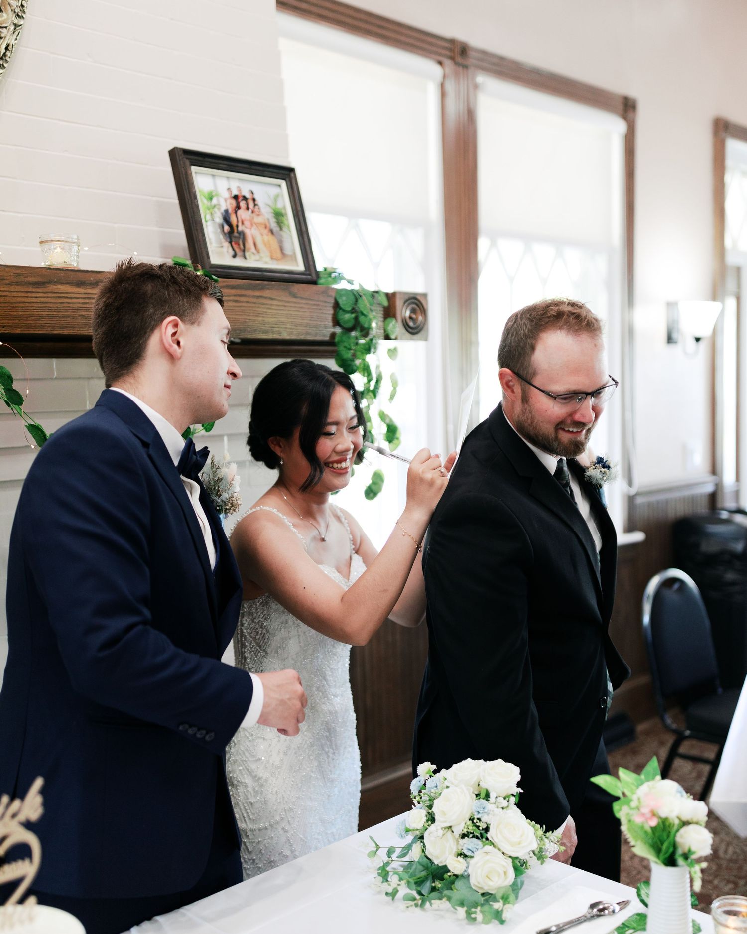 Wedding reception scene with elegant white floral centerpieces and decor.