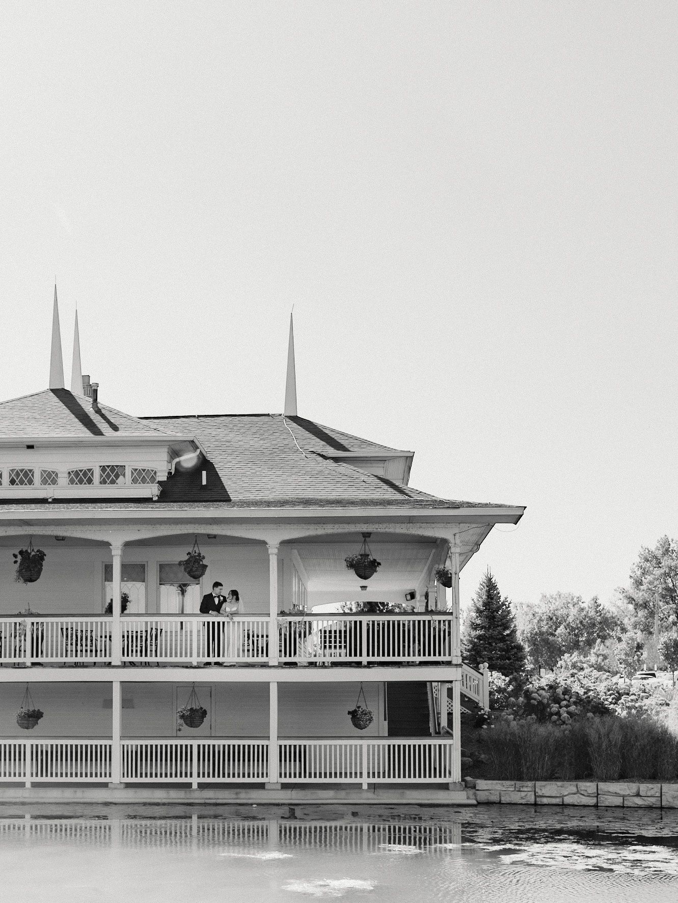 Black and white architectural photo of a grand Victorian-style building with wraparound porches.