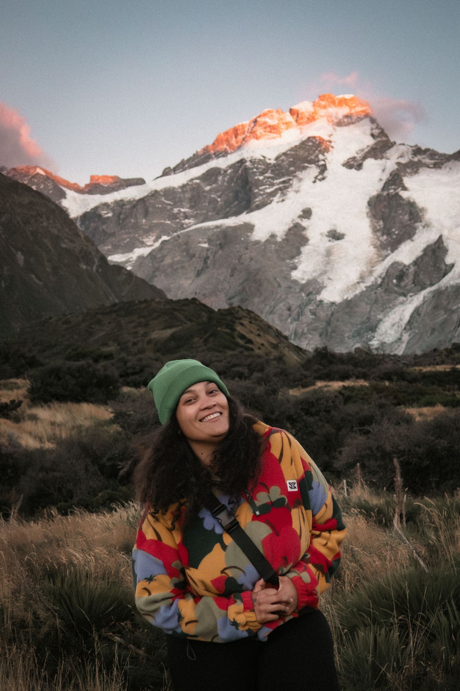 A snowy mountain peak silhouetted against a dramatic sunset sky in Mt Cook National Park.
