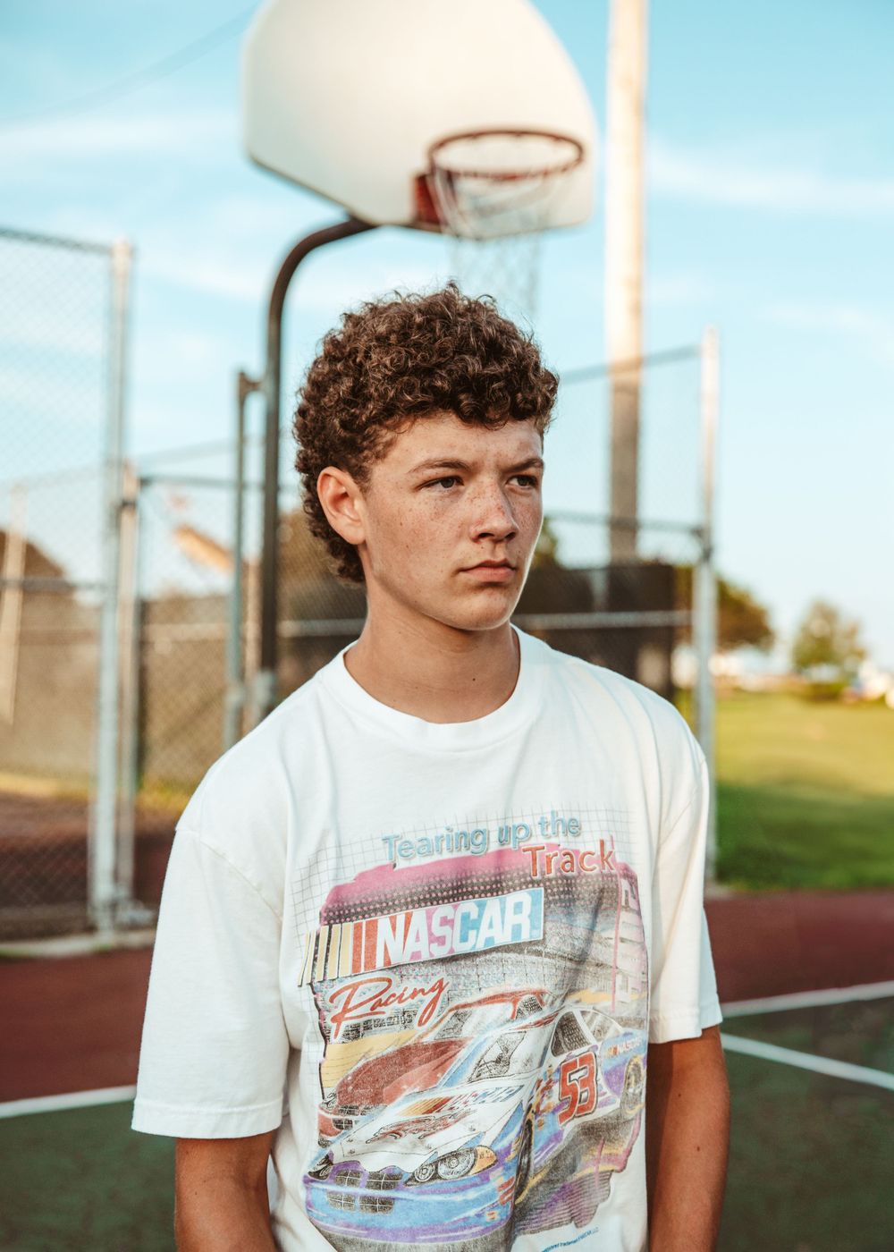 Casual portrait at basketball court wearing vintage NASCAR t-shirt.
