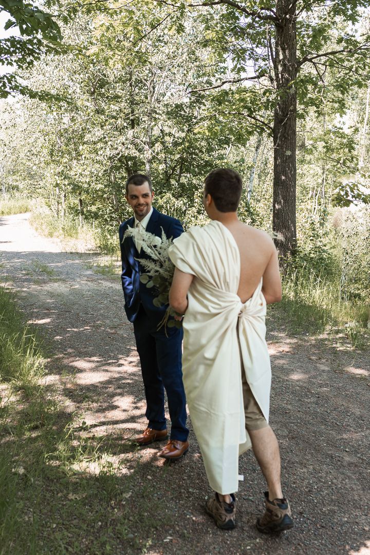 Groomsman surprising groom with first look photo in a dress
