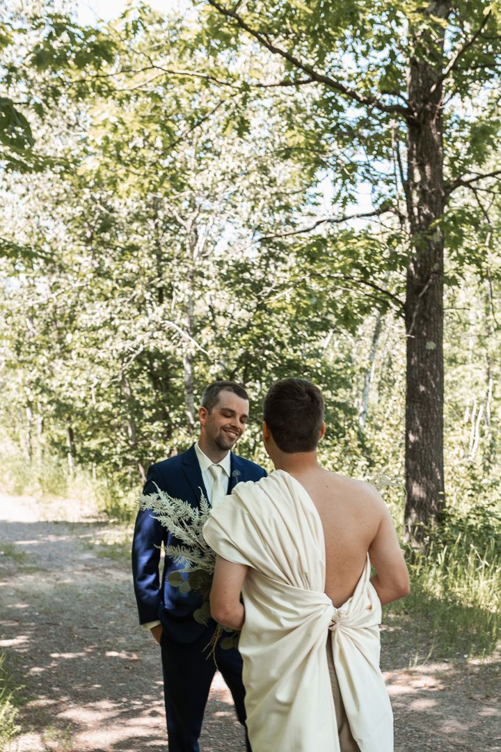 Groom laughing at Groomsman surprising groom with first look photo in a dress