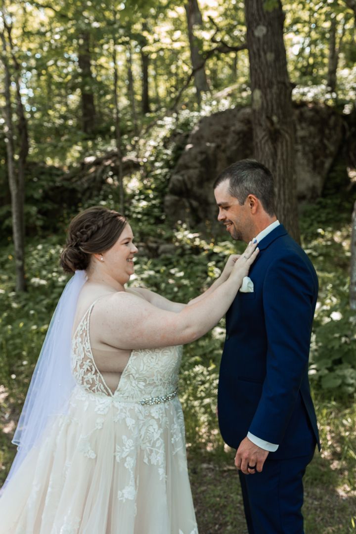 First look of Bride and Groom at Spirit Mountain in Duluth - Bride picks lint off shoulder
