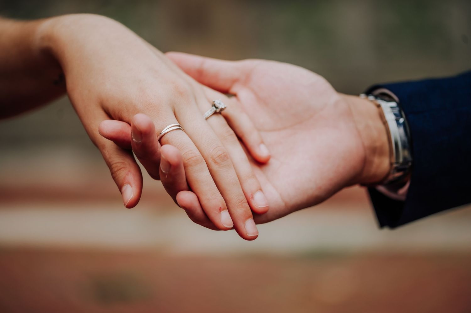 Close-up of hands showing engagement ring in romantic gesture.