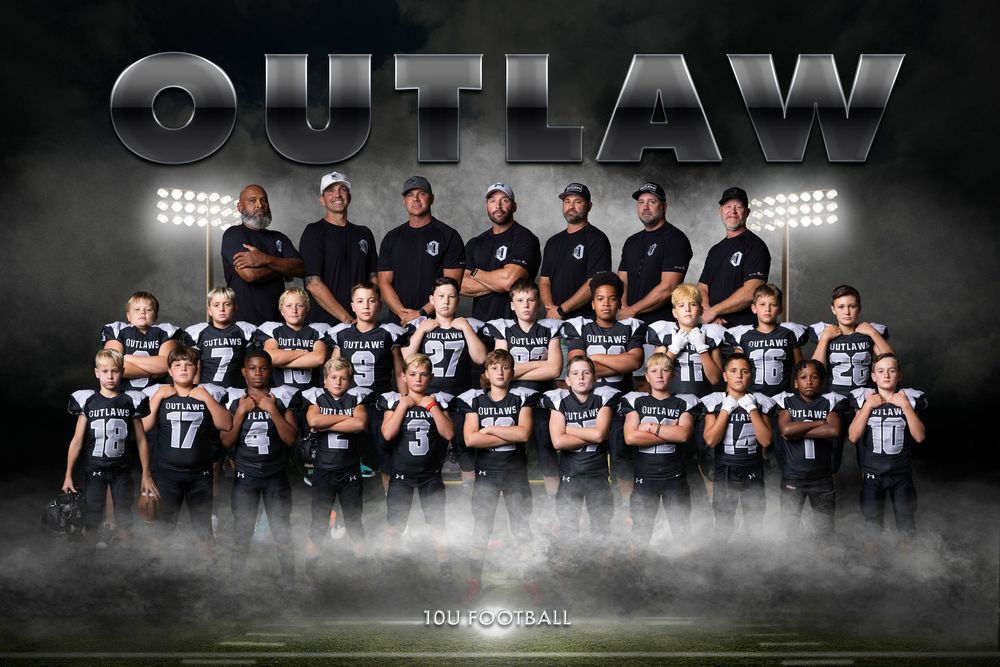 Team photo of youth football program with coaches in black and players in light jerseys against dark backdrop.