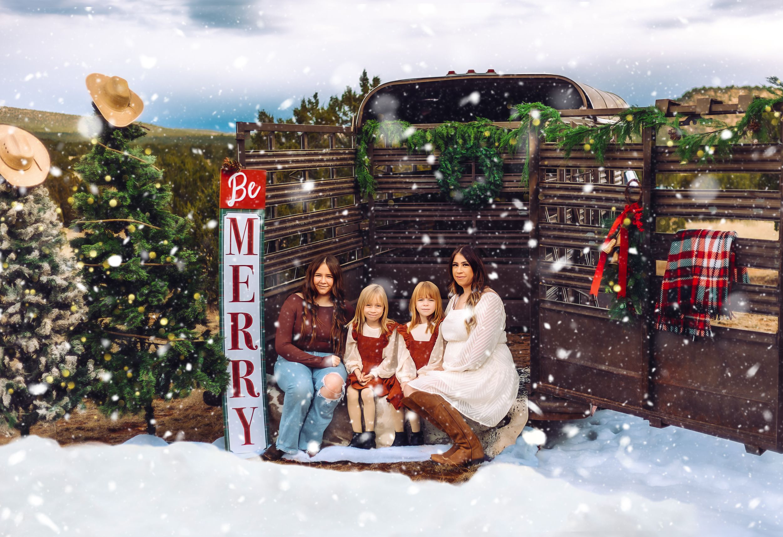 A holiday scene with people and a dog sitting in front of a rustic backdrop with snow and Christmas decor.