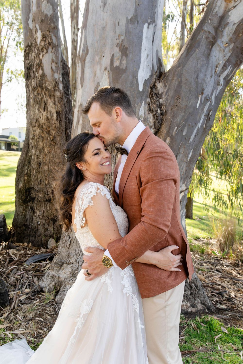 Romantic moment between couple under large eucalyptus tree.