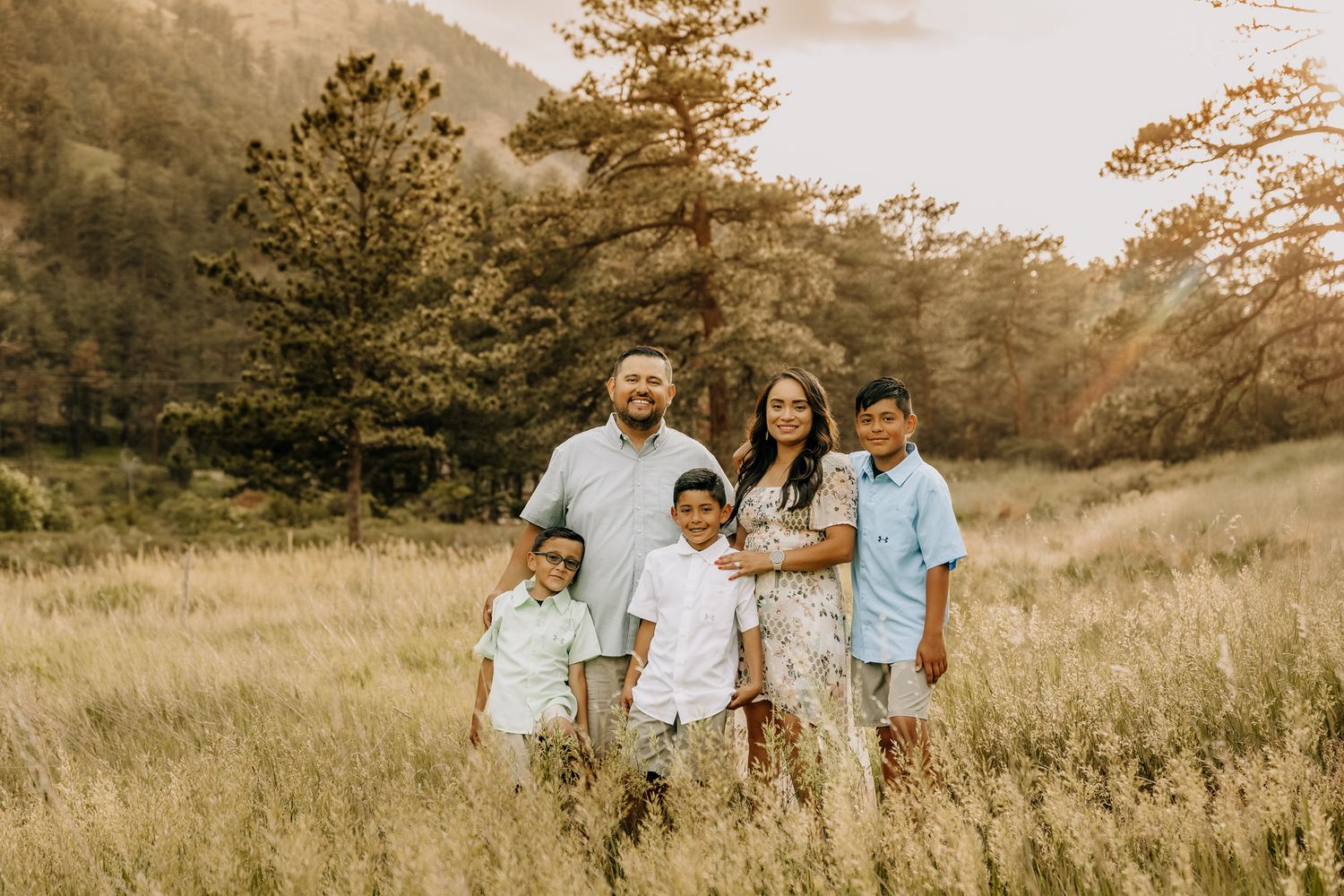 professional colorado family photo session in rocky mountains family of 4 posing in the mountains during sunset golden hour time. liz rivas