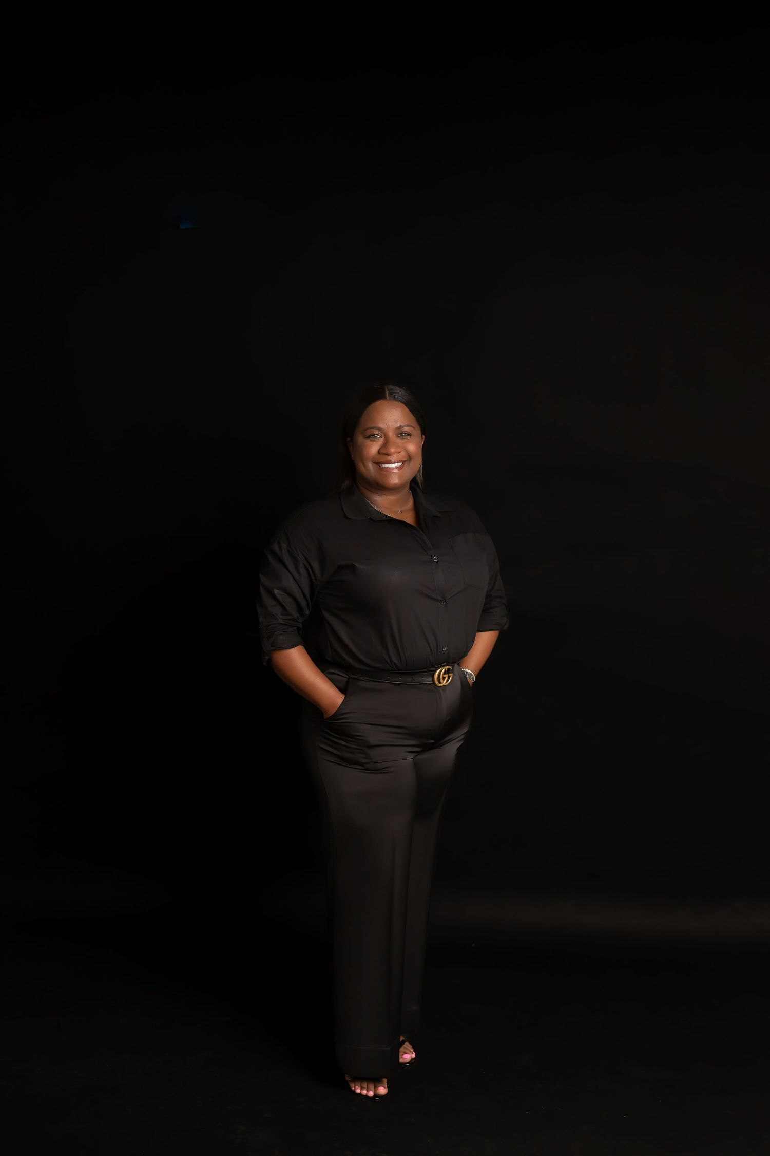 Professional studio portrait featuring vibrant hot pink blazer and white blouse against dark background.