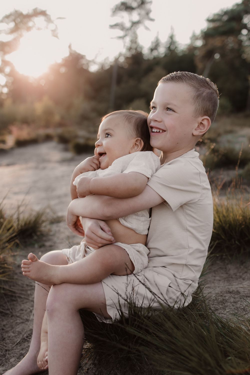 Twee broertjes tijdens een zonsondergang van een gezinsshoot in de natuur.