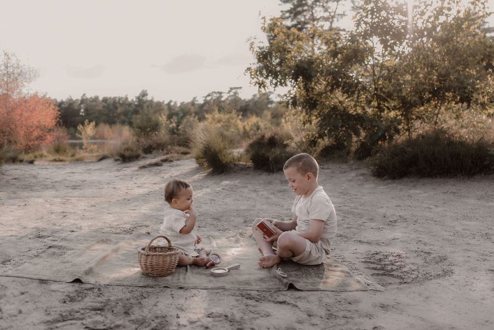 Twee kinderen spelend bij een prachtige zonsondergang.