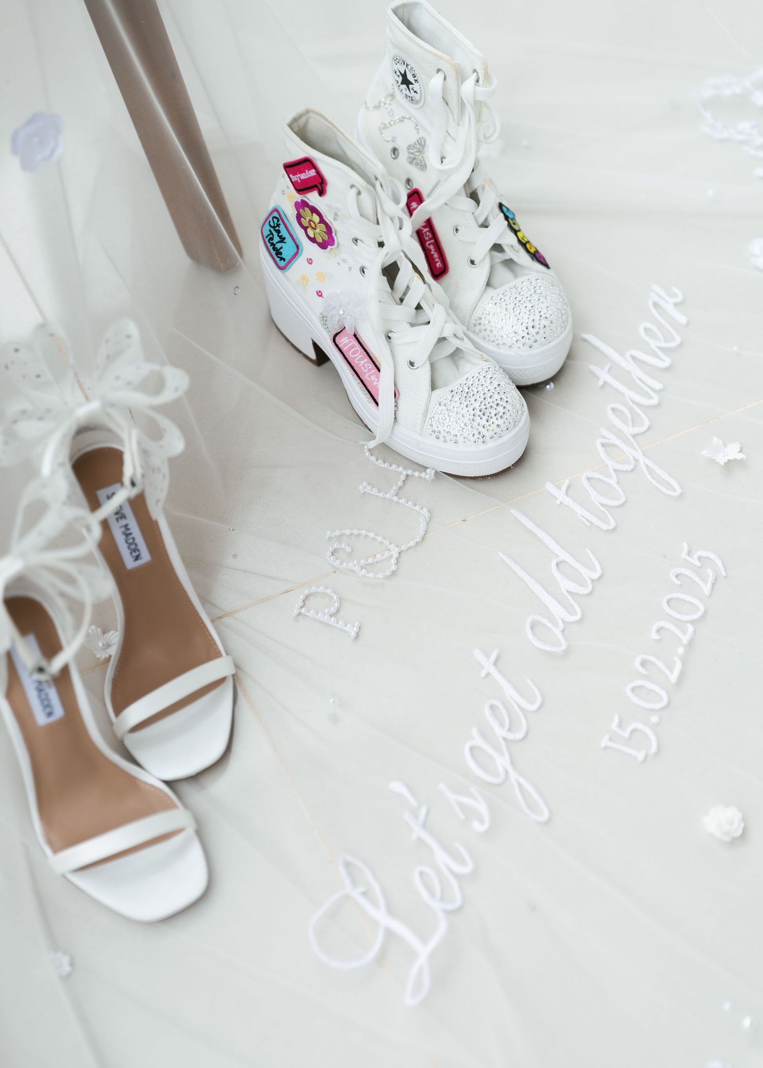 Two pairs of white shoes - decorated sneakers with patches and elegant strappy sandals arranged on a light background.