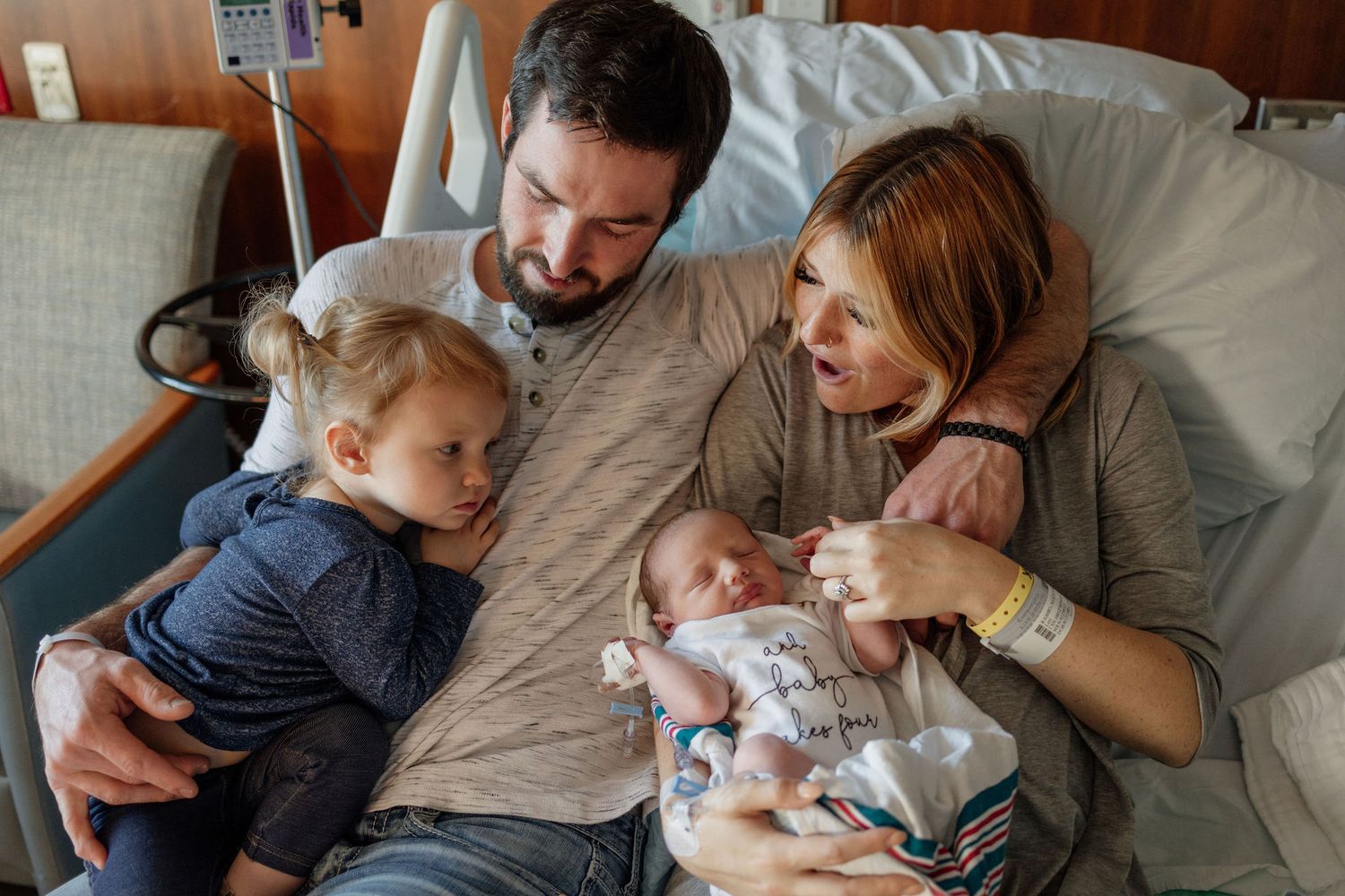 Kayla Ann Photography Grand Rapids MI Newborn Photographer Mom Dad and Older Sister snuggling newborn brother in hospital bed.