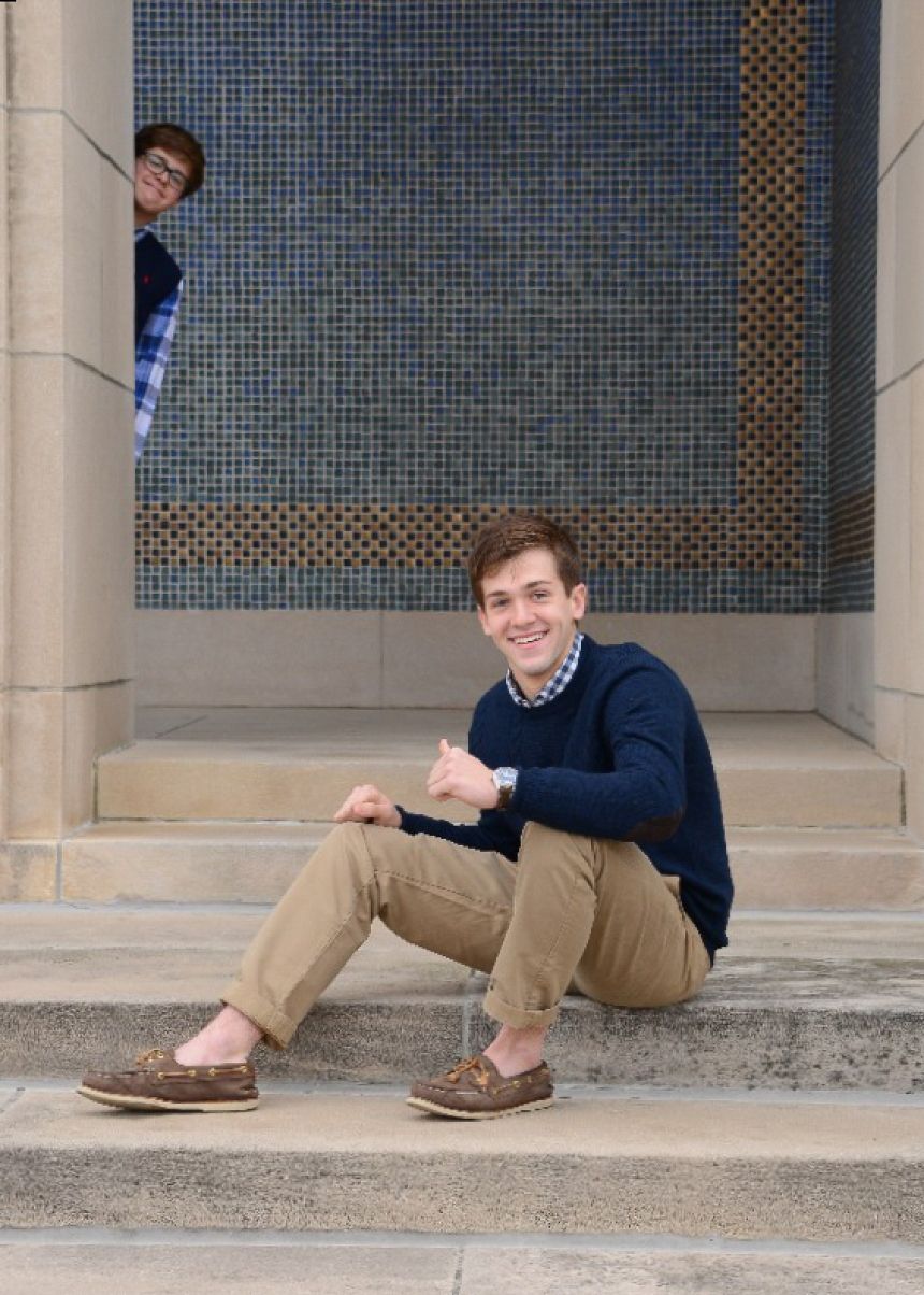 Casual portrait on stone steps with blue mosaic wall background.