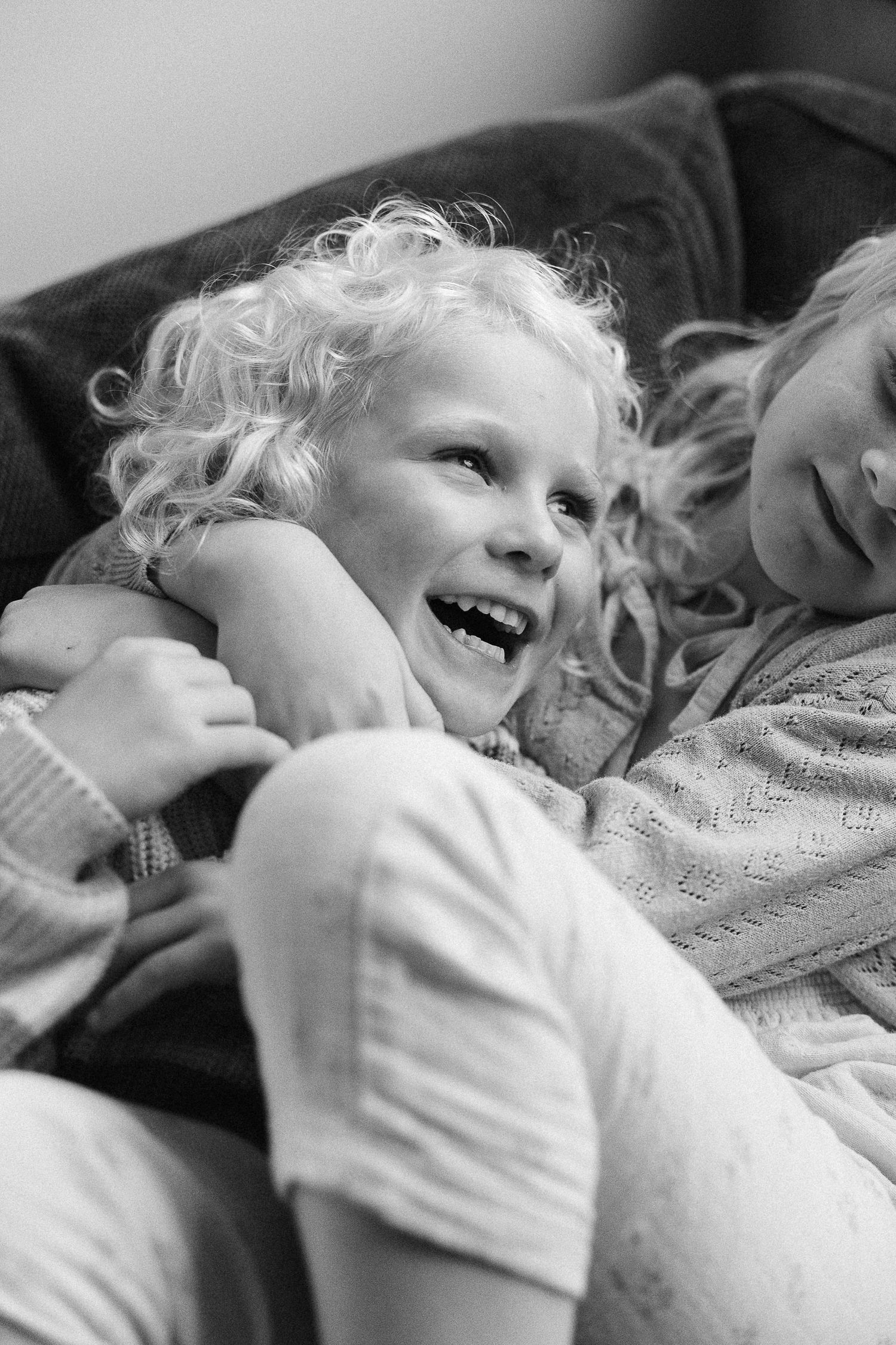 A joyful candid moment captured in black and white showing pure laughter and happiness.