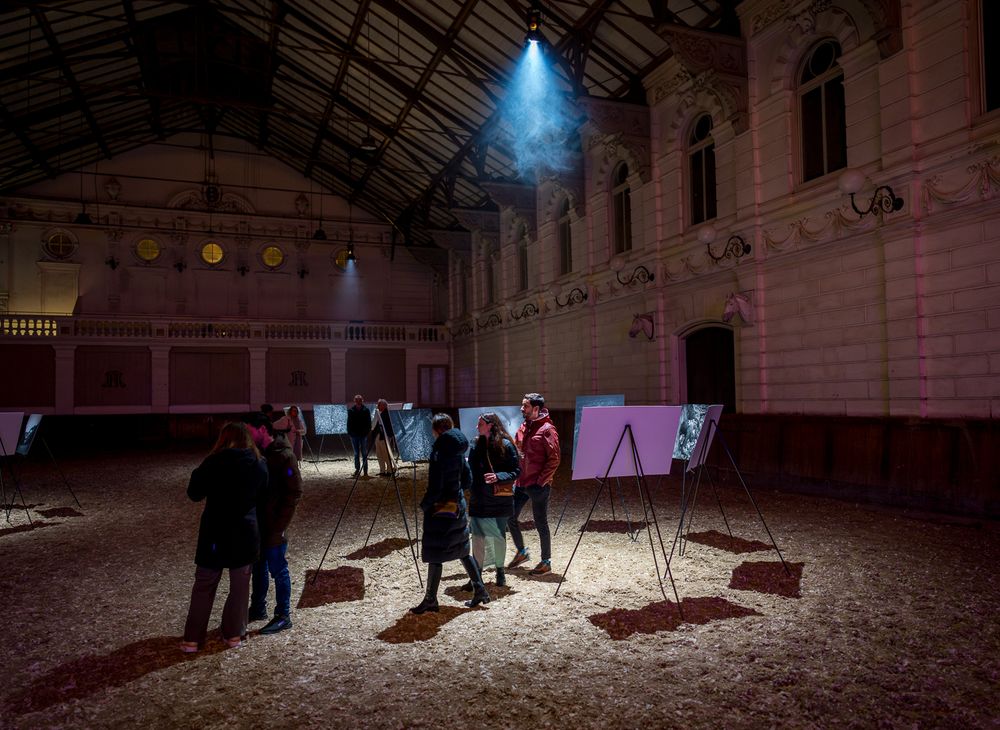 Art installation in a dimly lit historic hall with spotlights creating dramatic atmosphere.