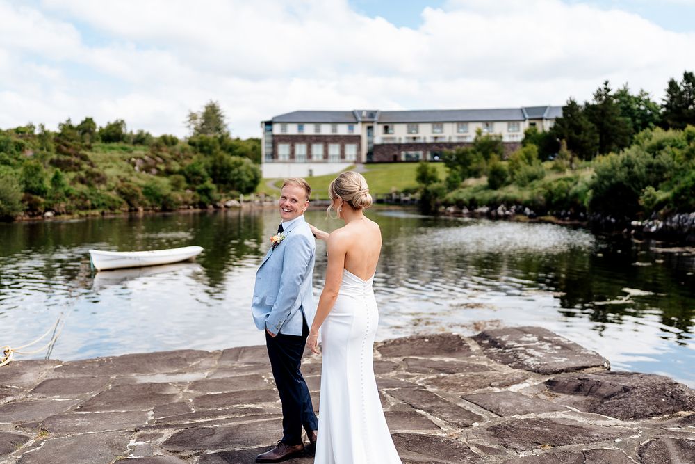 A scenic lakeside wedding ceremony setting with a stone ledge overlooking tranquil waters and natural surroundings.