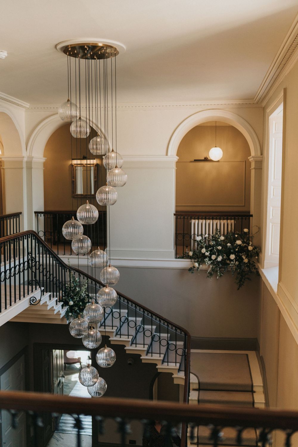 Modern light fixtures with hanging glass orbs illuminate an elegant staircase at Saltmarshe Hall - taken by Grimsby photographer.