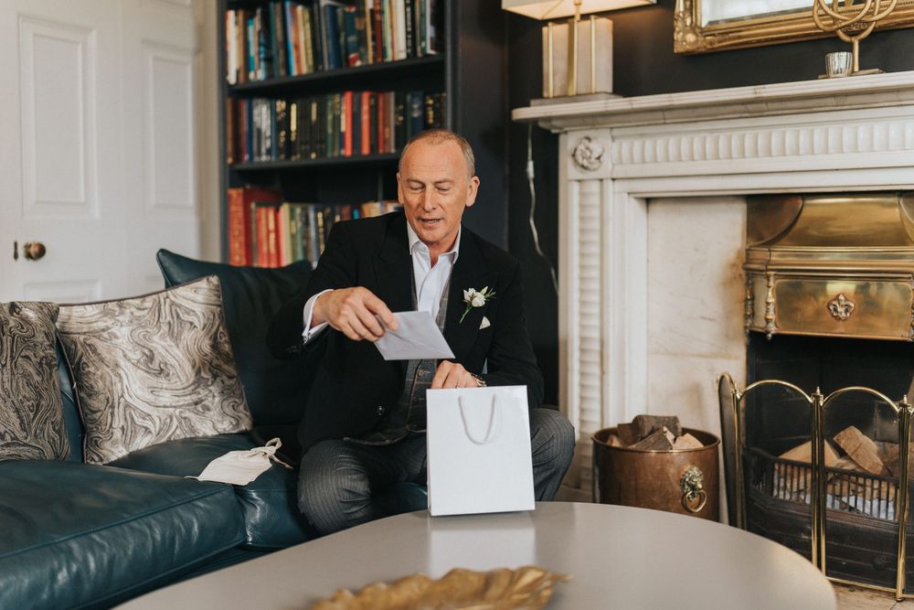 Professional photo shoot in an elegant room featuring book shelves, fireplace and leather furniture at Saltmarshe Hall.