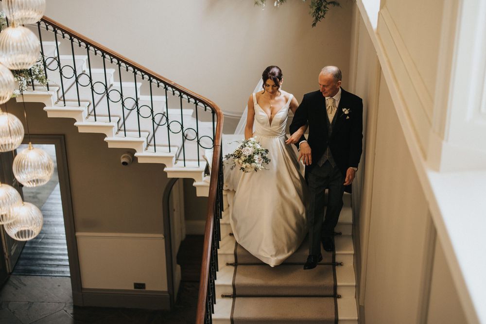 Bride and father descend down elegant staircase at Saltmarshe Hall - taken by Grimsby photographer.