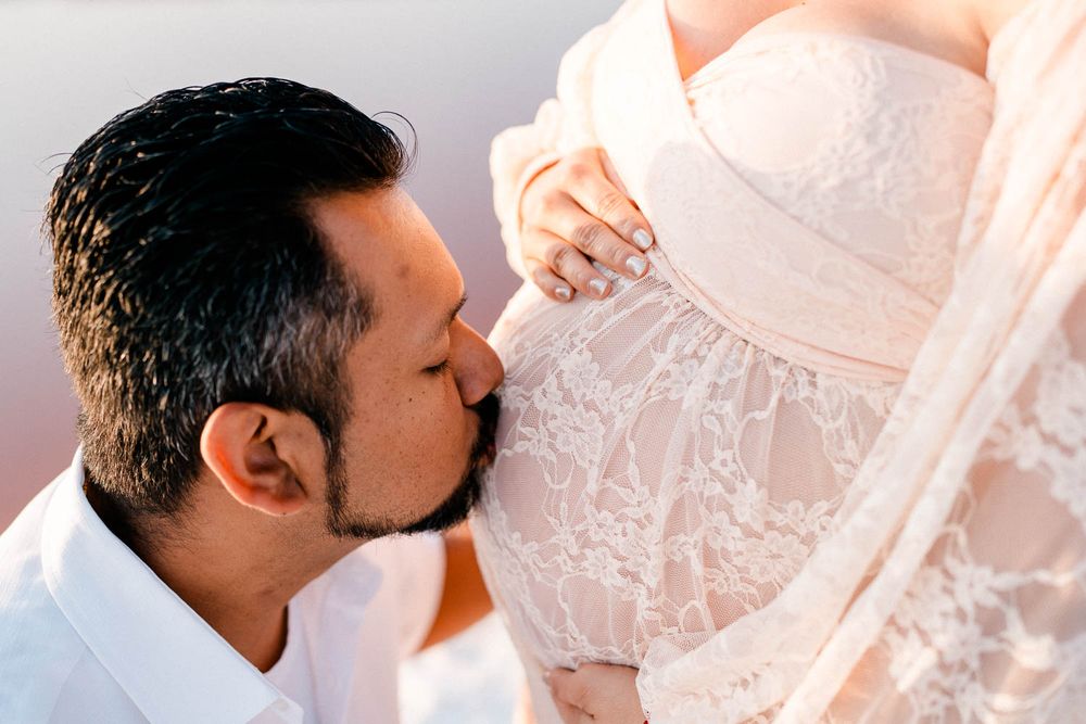 A happy couple wearing traditional Indian wedding attire embrace during their ceremony.