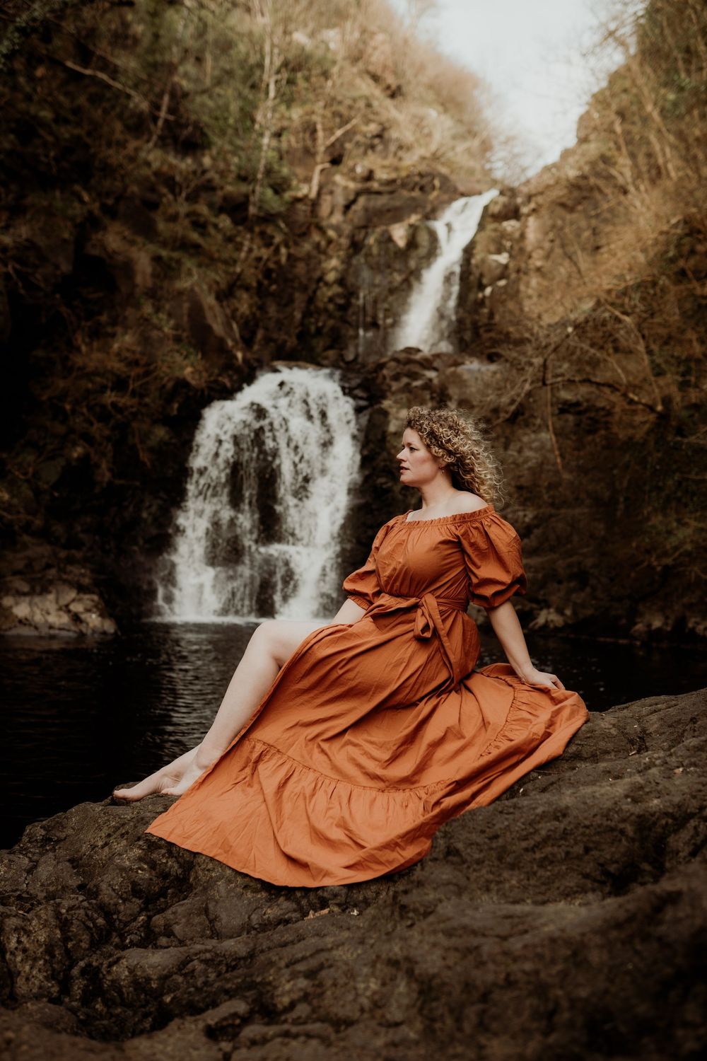 Vrouwenportret in de natuur bij verborgen waterval op Isle of Skye, Schotland