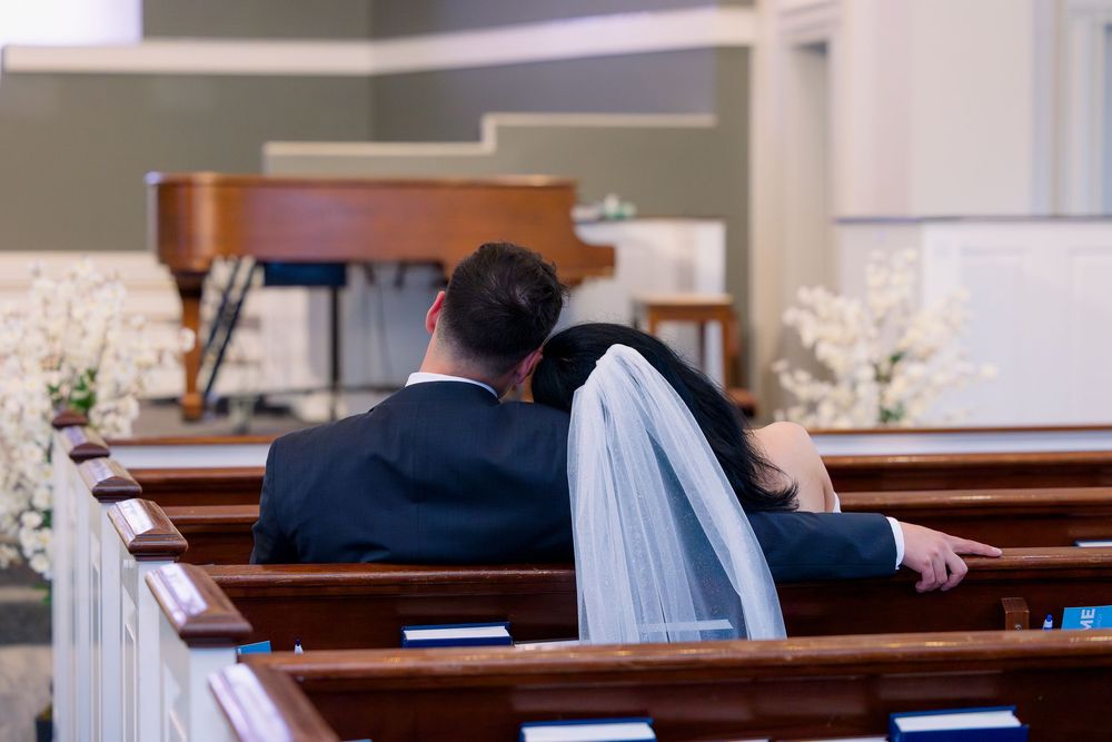 Professional couple signing important documents at a desk while meeting with an advisor.