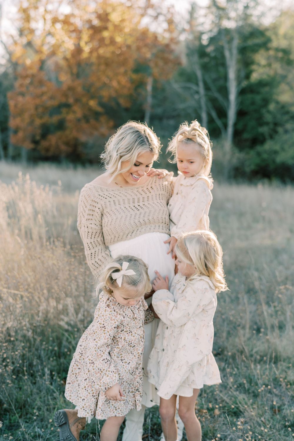 Tender family moment captured in golden autumn field with coordinating outfits.
