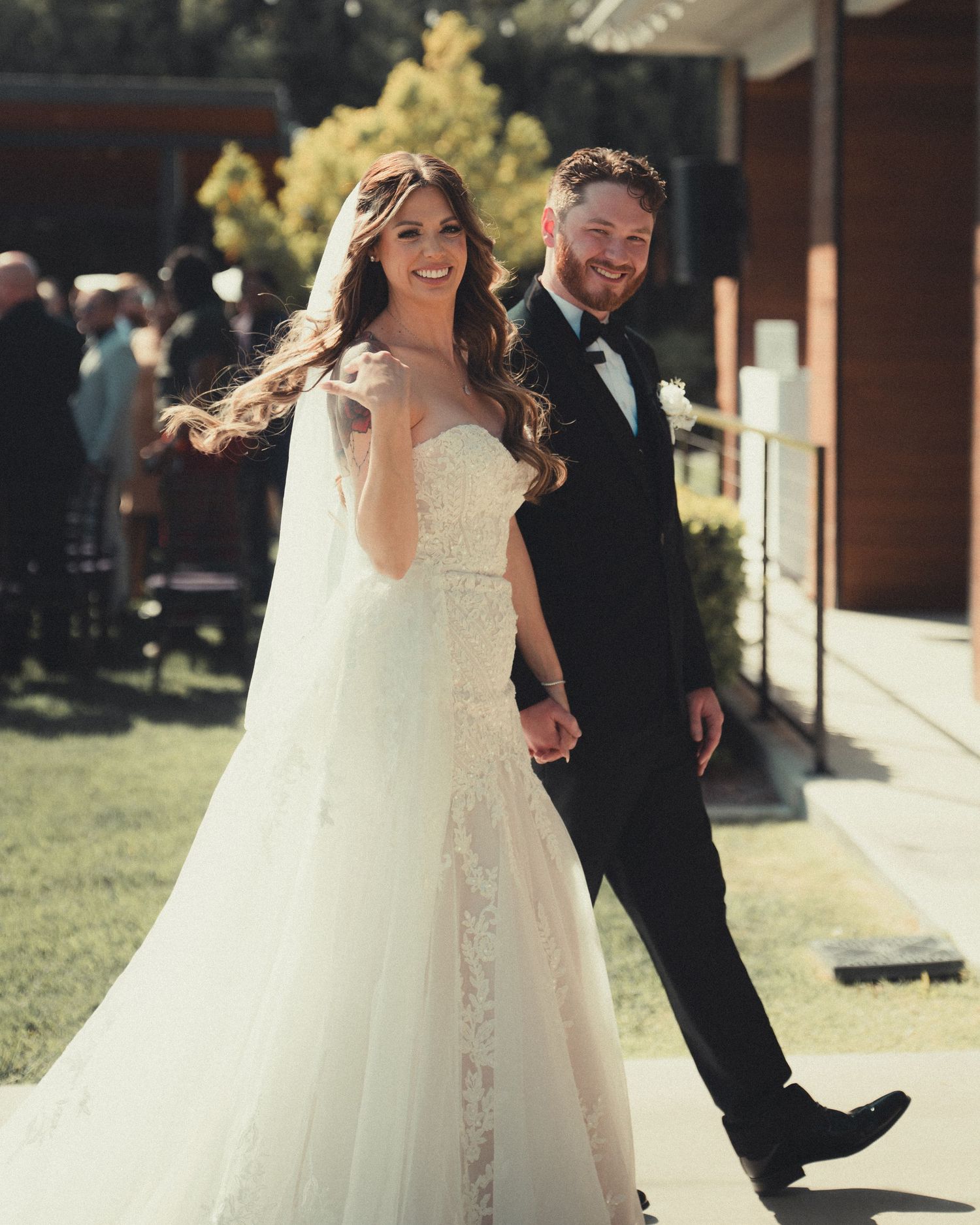 A bride and groom walk back down the aisle after taking their vows and laugh together.