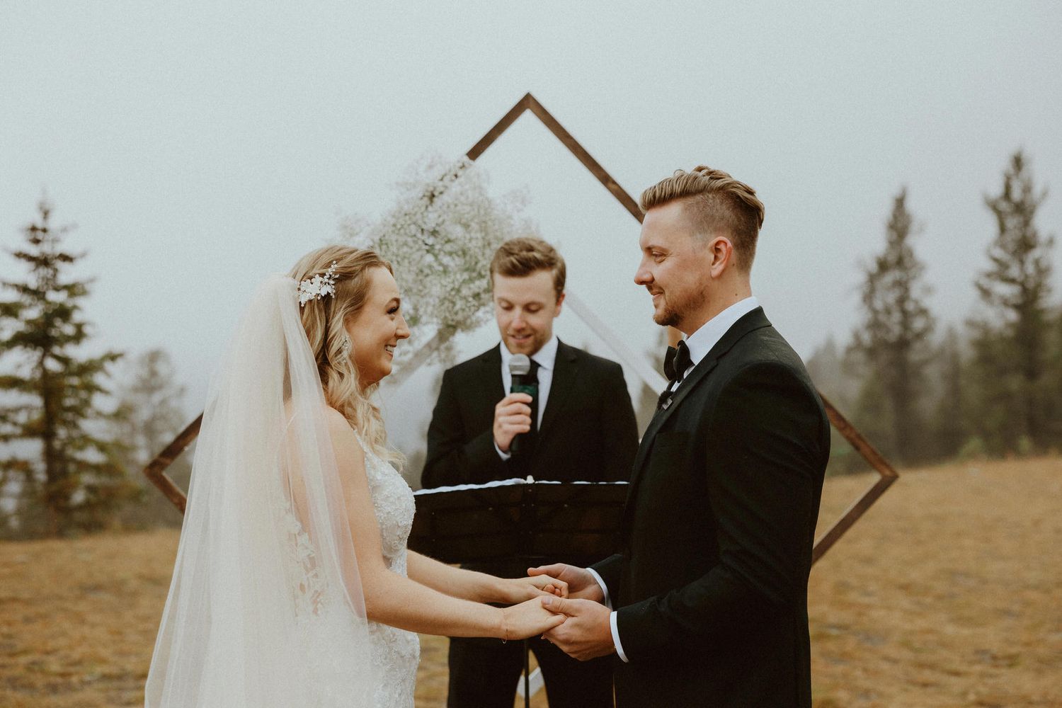 Outdoor wedding ceremony at Quarry Lake Park in Canmore with stunning Rocky Mountain backdrop by Calgary wedding photographer.